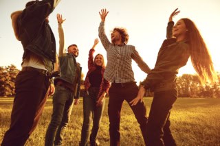 Young people cheerfully raised their hands up.