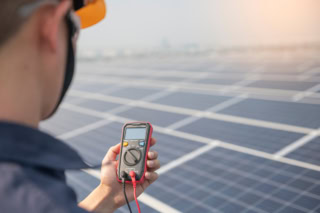 Engineer holding  sets the operation of the solar panel on the roof of the building to work at full efficiency.Using solar cells is energy saving. Renewable energy concepts.